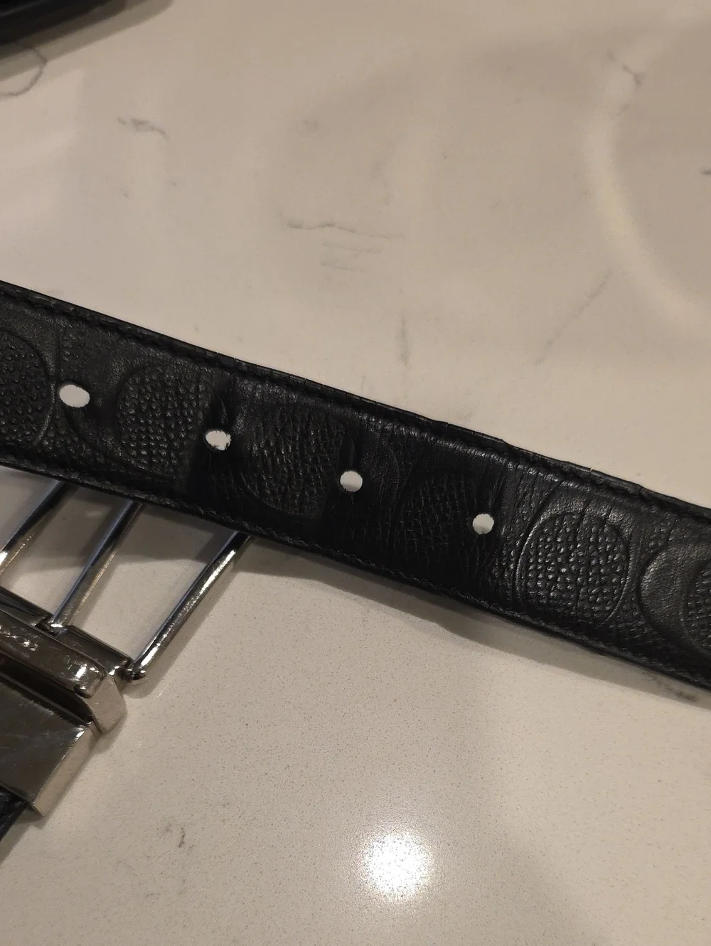 Black leather Coach belt. Reversible embossed Coach signature logo on one side.